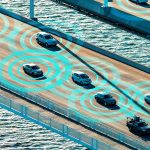 Bridge over sea with cars in motion.