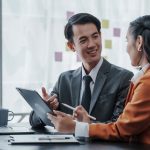 Two people in an office discuss the different types of vehicle fleet leases