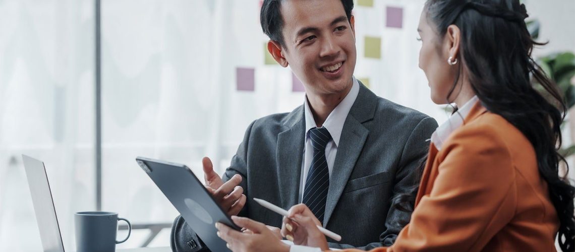 Two people in an office discuss the different types of vehicle fleet leases